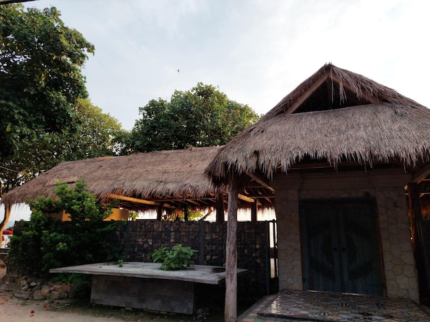 The exterior of thatched house on beach with clear sky