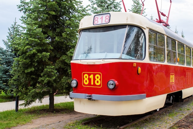 818番の展示物としての鉄道のヴィンテージの赤と白の路面電車の外観、周囲の緑、キシナウ、モルドバ