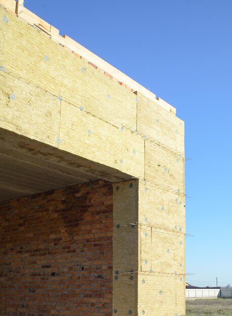 Exterior wall heat isolation with mineral wool in private house building under construction