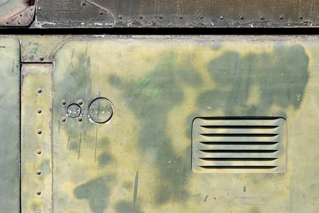 The exterior wall surface of the military helicopter is very old military green paint peeling off There is a vent in the lower right side of the picture in the bright sunlight during the day