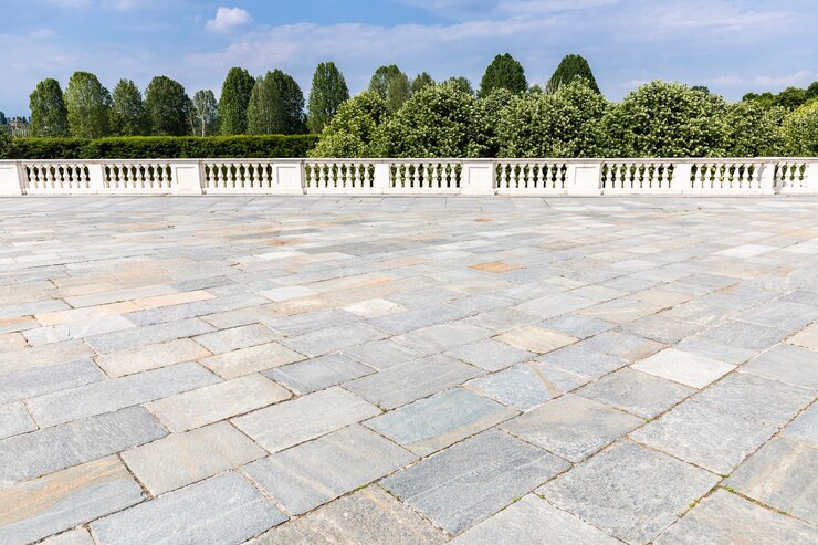 Photo exterior with old grey floor made of stone. vintage textured pavement and blue sky in the background.
