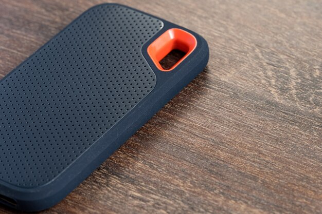 an external ssd drive isolated on wooden background. selective focus.