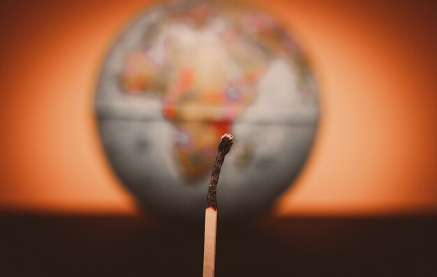 Photo extinct match on blurred world globe