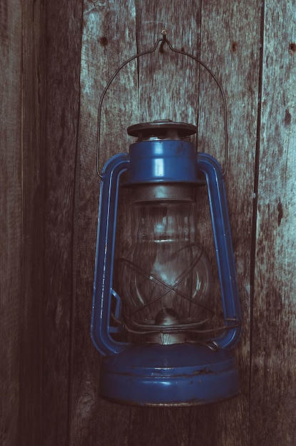 Photo extinguished the kerosene lamp hangs on old wooden wall in the morning