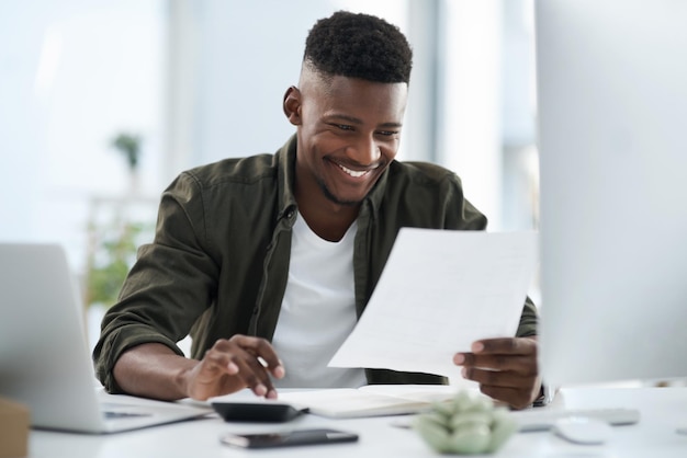 extra effort gets rewarded shot of a young businessman working on a computer in an office