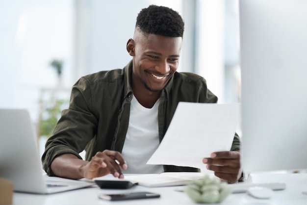 Extra inspanning wordt beloond Shot van een jonge zakenman die op een computer in een kantoor werkt