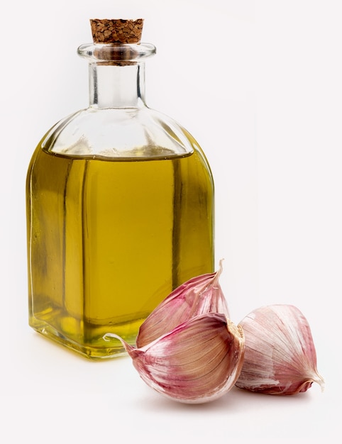 Extra vierge olijfolie in een rustieke glazen fles met paarse knoflook