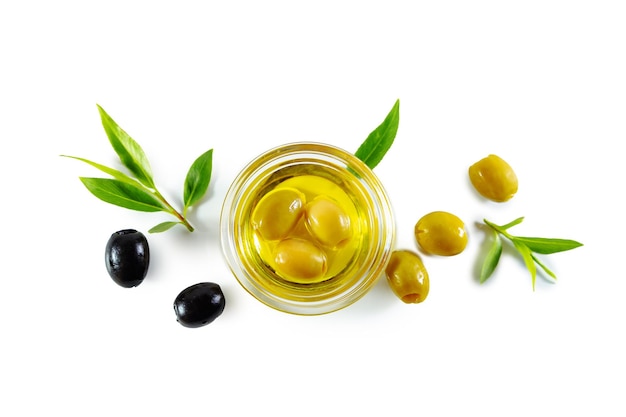 extra virgin olive oil in a transparent bowl and black and green olives with leaves