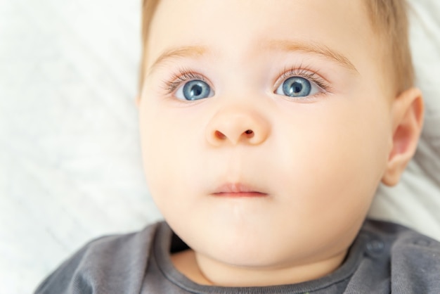 Extreem close-upportret van een tien maanden oude babyjongen. Blauwe ogen roodharig klein kind.