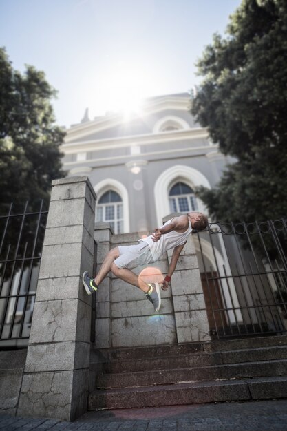 Extreme athlete doing a backflip in front of a building