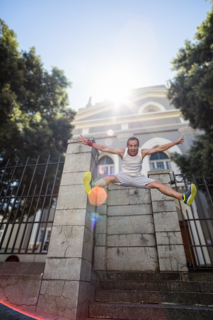 Extreme atleet die in de lucht voor een gebouw springt