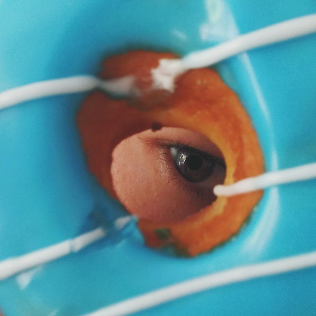 Extreme close-up of eye looking through donut