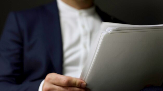 Extreme close up for a man during reading contract and turning the page isolated on grey background