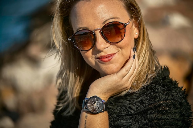 Extreme closeup portrait of a blonde girl with glasses and wristwatch