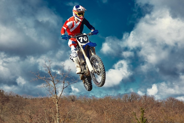 Экстремальная концепция бросить вызов себе экстремальный прыжок на мотоцикле на фоне голубого неба с