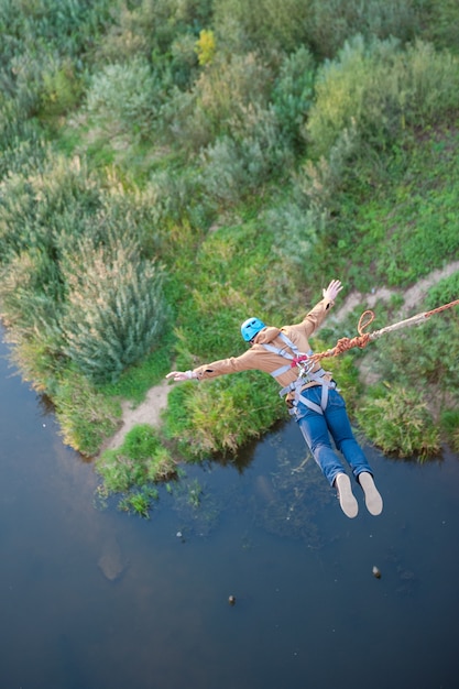 Salto estremo dal ponte. l'uomo salta sorprendentemente rapidamente nel bungee jumping allo sky park esplora il divertimento estremo. bungee nel canyon.