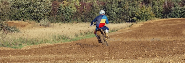 ダートトレイルに乗っているエクストリームモトクロスMXライダー