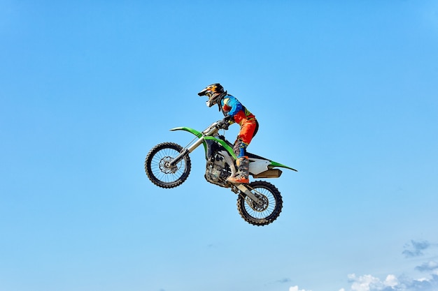 Photo extreme sports, motorcycle jumping motorcyclist makes an extreme jump against the sky