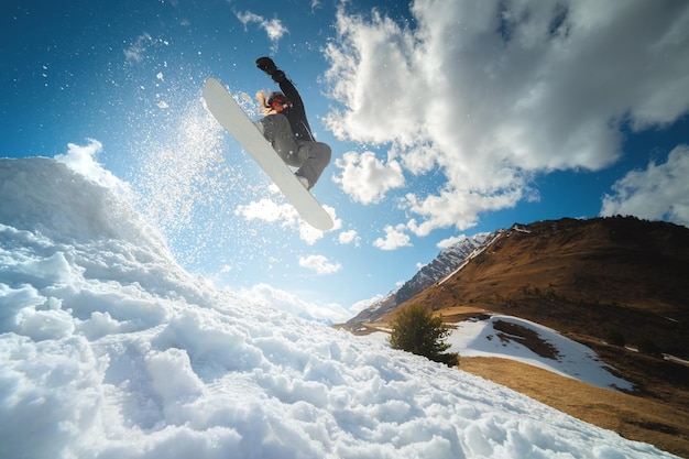 Foto sport invernali estremi giovane professionista donna snowboarder cavalca un halfpipe salta da un halfpipe