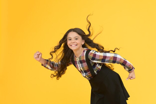 Extremely effective product Child with natural beautiful healthy hair yellow background Tips for healthy hair Towards the wind Natural beauty Girl kid long hair flying in air Growing hair