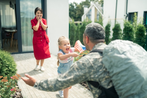 Extremely emotional. Cute little daughter feeling extremely emotional seeing daddy after military service
