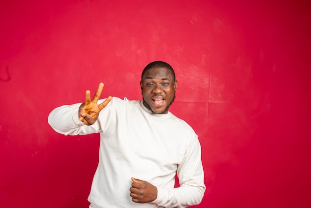 Extremely happy excited young african american man win lottery bet standing pleased jumping joyfully