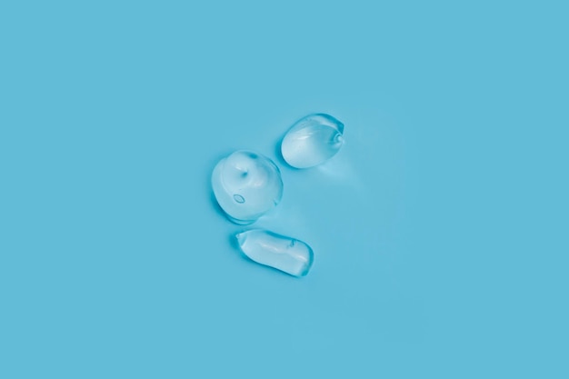 An extruded transparent gel as a sample of a cosmetic product on a blue background Top view flat lay