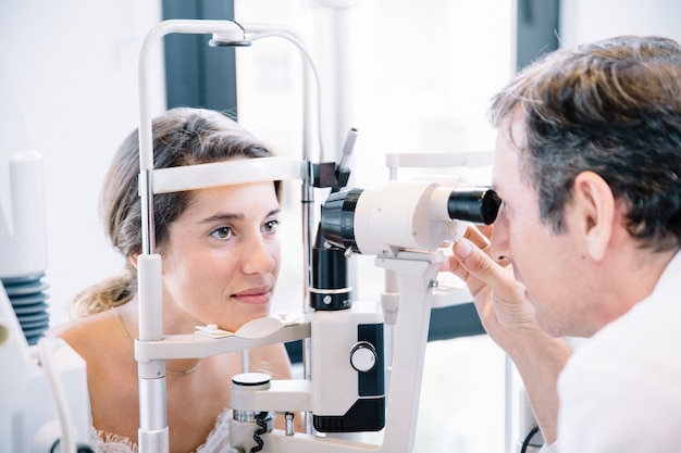 Photo eye doctor examinating a young patient