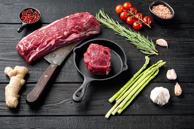 Eye Fillet beef marbled fresh meat steak set, on frying cast iron pan, on black wooden table