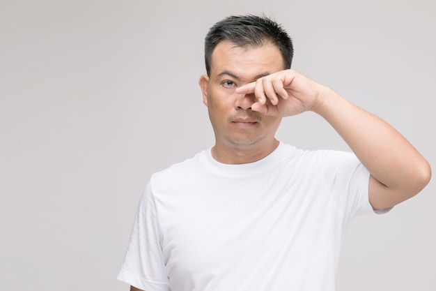 Eye irritation concept : Portrait of Asian man in posture of eye tired,  irritation or problem about his eye. 