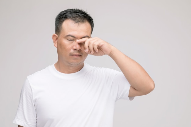 Eye irritation concept : Portrait of Asian man in posture of eye tired,  irritation or problem about his eye. 