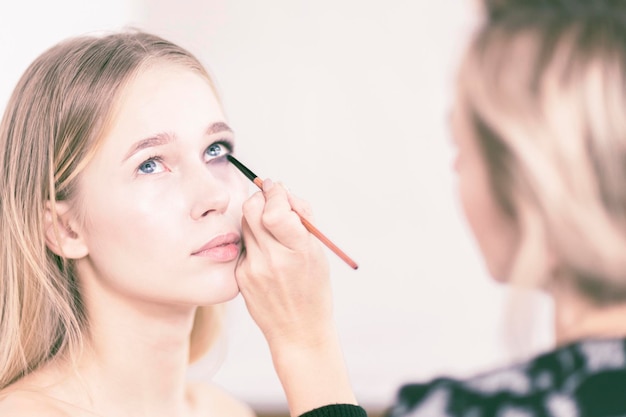 Eye makeup Makeup artist paints the girl's eyes