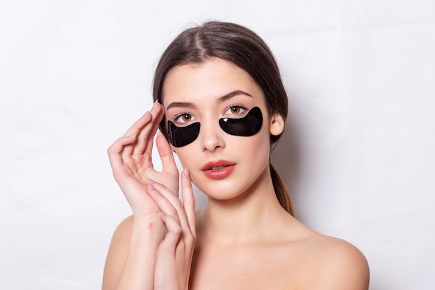 Eye patch, Beautiful Woman With Natural Makeup And Black Hydro Gel Eye Patches On Facial Skin. Caucasian woman use black patches after shower, skin care