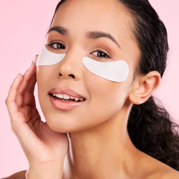 Eye patch face mask and beauty of a woman with natural skin glow on a pink background Dermatology collagen and cosmetics portrait of female model for facial shine wellness or self care in studio