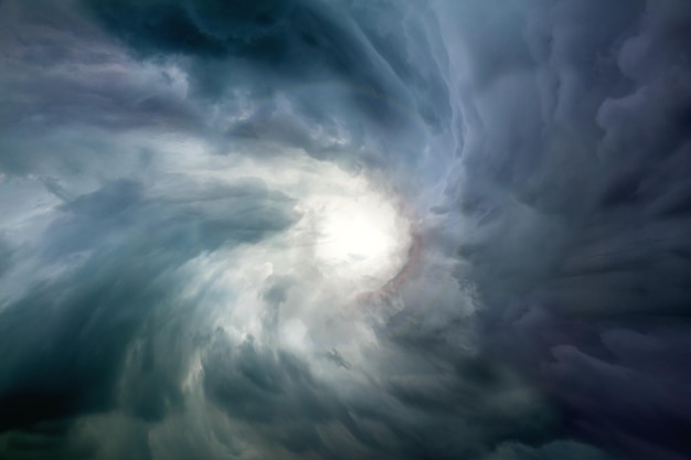 Eye of the sky and light in the dark Dramatic stormy clouds sky Danger and Hope Conceptual sky background