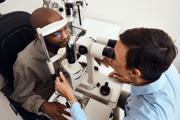 Eye vision or sight test or exam of a patient above at an optometrist optician or ophthalmologist Testing and checking eyesight on a ophthalmoscope for optical glasses or contact lenses at clinic