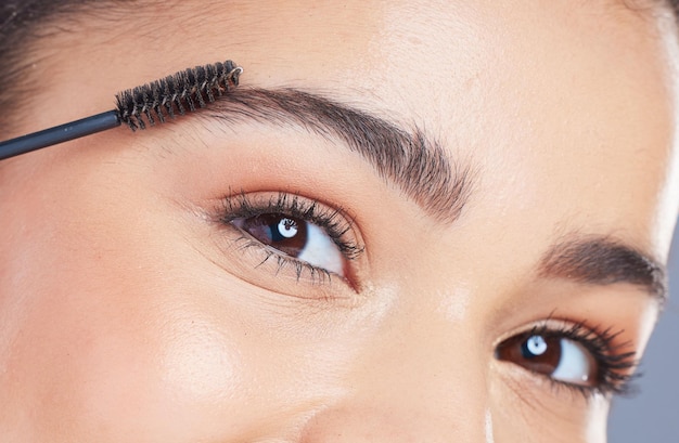 Foto il ritratto del pennello per sopracciglia e gli occhi della donna applicano il trucco per la cura della fronte, la crescita dei capelli o i cosmetici per il viso