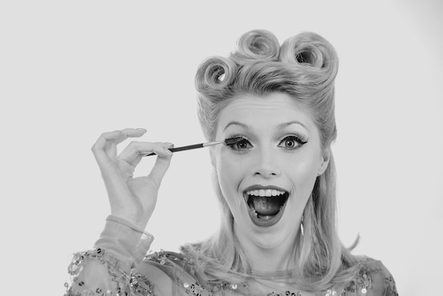 Eyebrow makeup blonde excited woman brushing brows with brows brush closeup pin up style