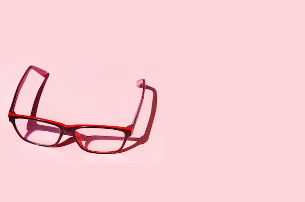 Photo eyeglass on pink background with shadows