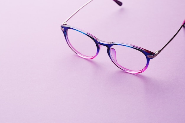 Eyeglasses in empty purple background