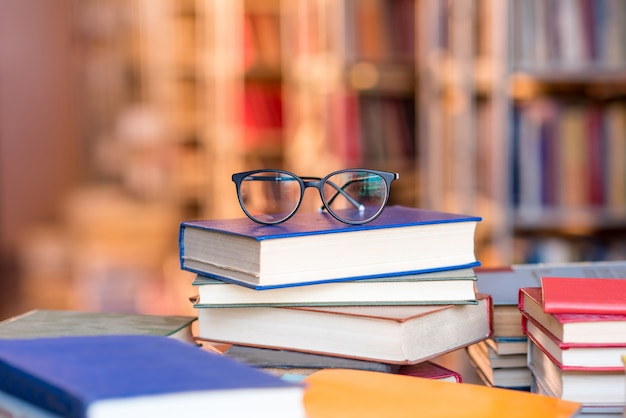 Occhiali da vista sdraiati sui libri in biblioteca. immagine con copia spazio