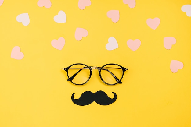 Eyeglasses with a black paper moustache and hearts