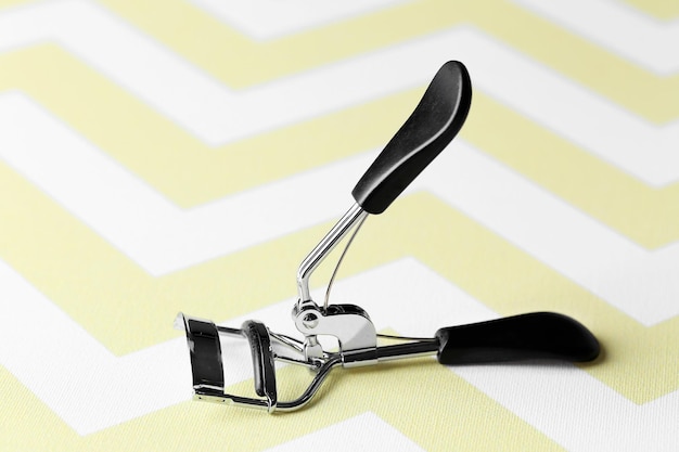 Photo eyelash curler with black handles close up