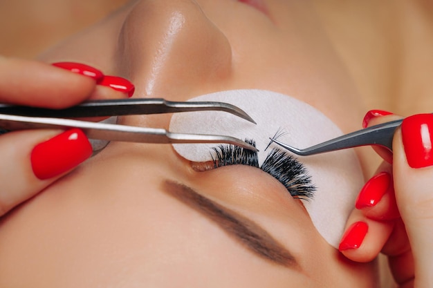 Eyelash extension procedure woman eye with long eyelashes close up selective focus