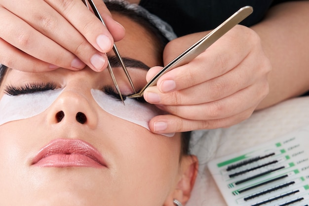 Photo eyelash extension procedure woman eye with long eyelashes