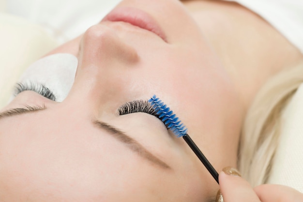 Eyelash extension procedure. young woman with long eyelashes in a beauty salon