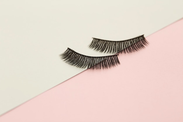 Photo eyelashes on pink and green paper backgorund. minimal creative idea