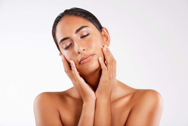 eyes closed skincare and beauty of woman dream of wellness results and glow on white studio background peace natural and model touch face with cosmetics for dermatology treatment shine and calm