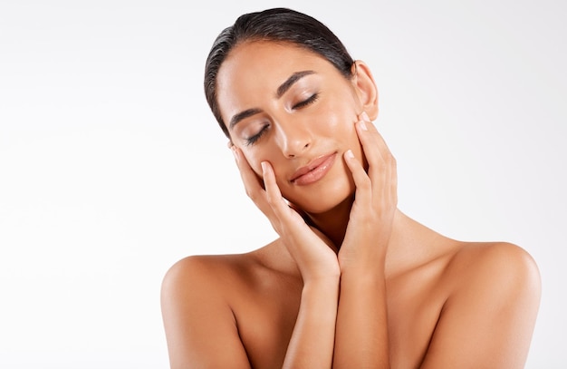 eyes closed skincare and woman touch face for wellness results and glow isolated on white studio background peace beauty makeup and model with cosmetics for dermatology treatment shine and calm