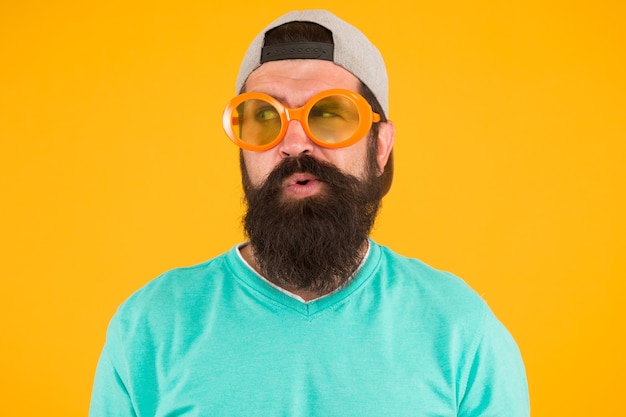 Eyes health. eyesight check ups. good vision. fun and
entertainment. funny accessory. man eyewear model. funny
sunglasses. bearded man in sunglasses orange background. hipster
wear party sunglasses.